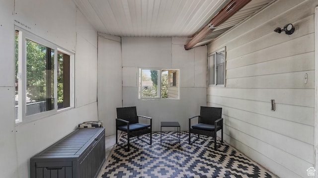 sitting room featuring tile patterned floors, wood walls, and wood ceiling