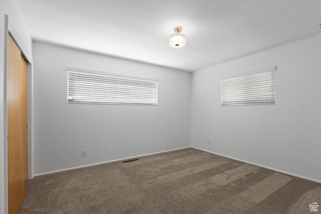 unfurnished bedroom featuring carpet floors, a closet, and baseboards