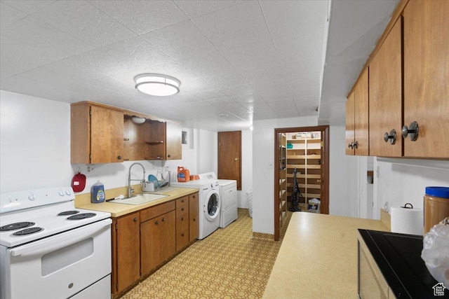 kitchen featuring white electric range, separate washer and dryer, a sink, light countertops, and light flooring
