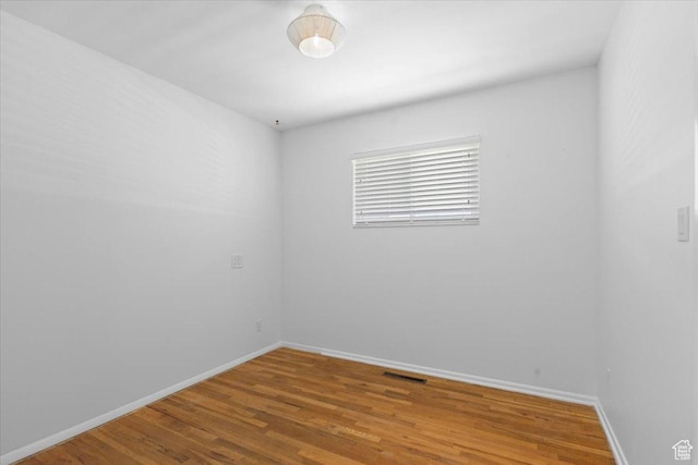 unfurnished room with wood finished floors and baseboards