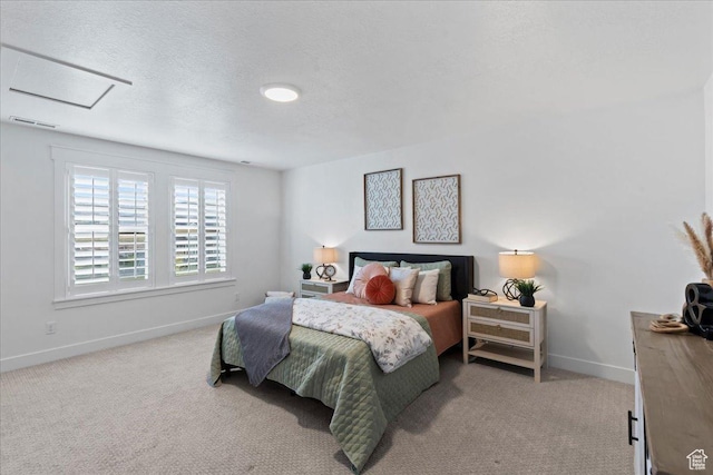 carpeted bedroom featuring attic access, baseboards, and a textured ceiling
