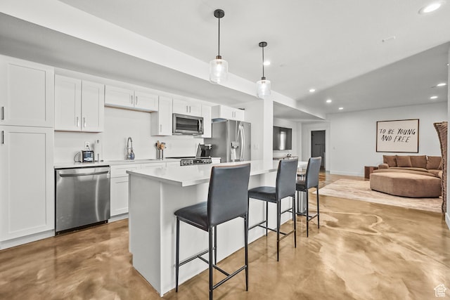 kitchen with stainless steel appliances, finished concrete floors, a breakfast bar area, recessed lighting, and white cabinetry