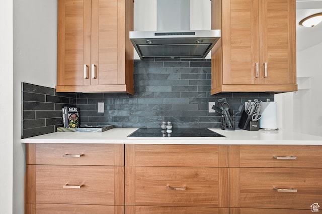kitchen with exhaust hood, black electric stovetop, tasteful backsplash, and light countertops