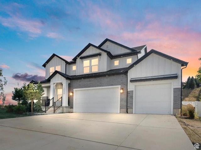modern farmhouse featuring board and batten siding, brick siding, and driveway