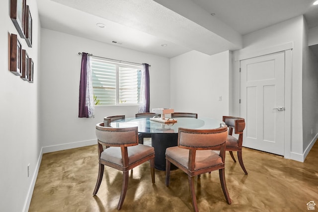 dining room with finished concrete flooring and baseboards