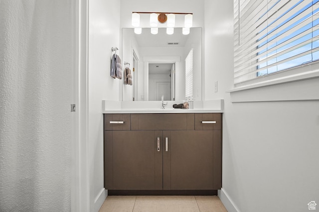 full bath featuring baseboards, vanity, and tile patterned floors