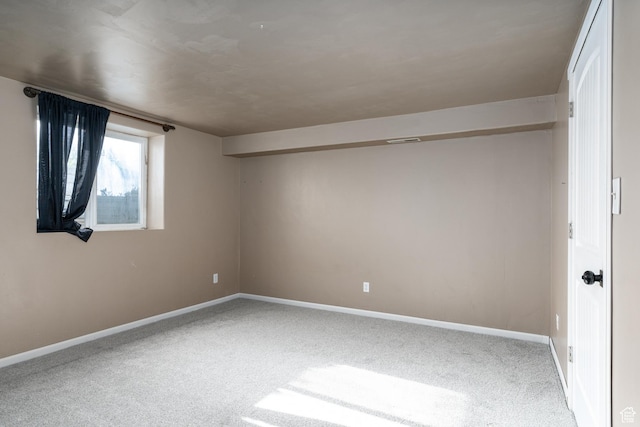 carpeted empty room featuring baseboards