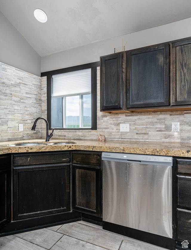 kitchen with dishwasher, a sink, tasteful backsplash, vaulted ceiling, and light stone countertops