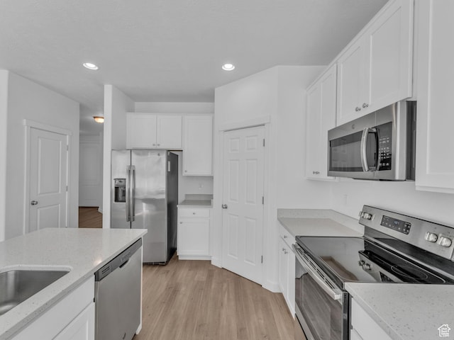 kitchen with appliances with stainless steel finishes, white cabinetry, and recessed lighting