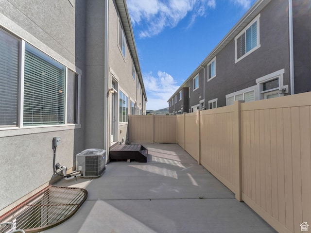 view of patio with central air condition unit and fence