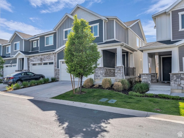 craftsman-style house featuring board and batten siding, stone siding, a garage, and driveway