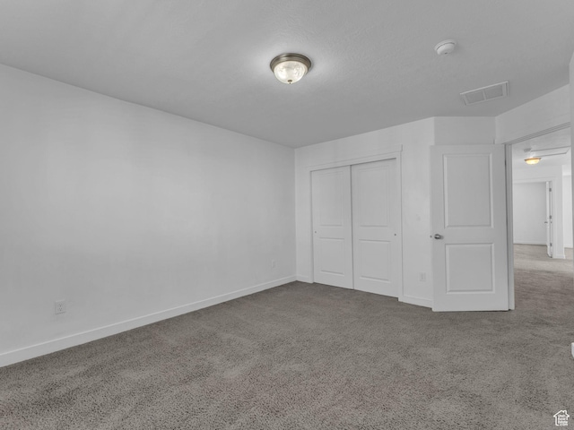 unfurnished bedroom featuring carpet flooring, baseboards, and a closet