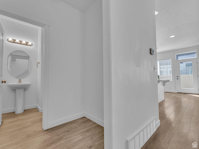 hall with wood finished floors and baseboards