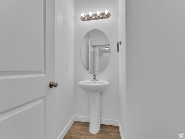 bathroom with wood finished floors and baseboards