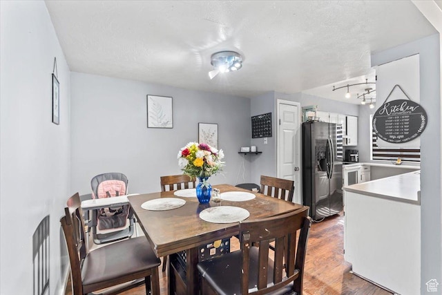 dining room with wood finished floors and a textured ceiling