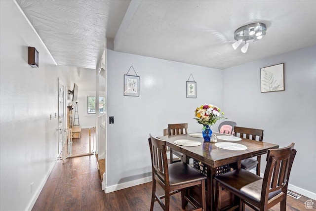 dining room featuring baseboards and dark wood-style flooring