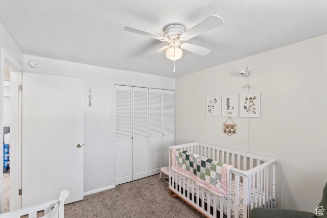 carpeted bedroom featuring a closet, a crib, and a ceiling fan