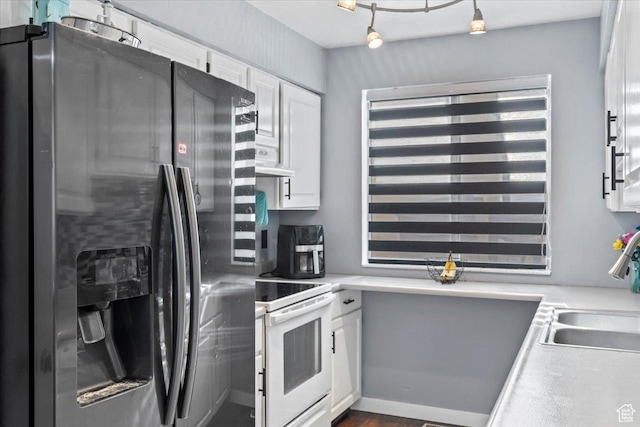 kitchen with stainless steel refrigerator with ice dispenser, electric stove, white cabinetry, a sink, and light countertops