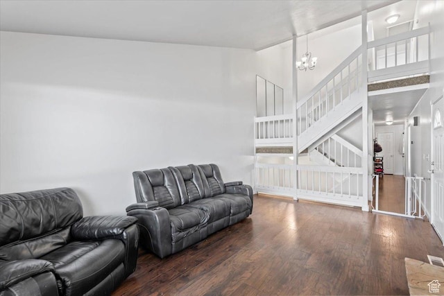 living room with a chandelier, wood finished floors, stairway, and a high ceiling