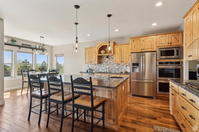 9288 N Harmony Way, Eagle Mountain, UT 84005 - kitchen featuring stainless steel appliances, light brown cabinetry, a breakfast bar, a sink, and dark wood-style floors