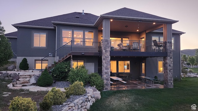 9288 N Harmony Way, Eagle Mountain, UT 84005 - rear view of house with a patio area, stucco siding, stairs, a lawn, and roof with shingles