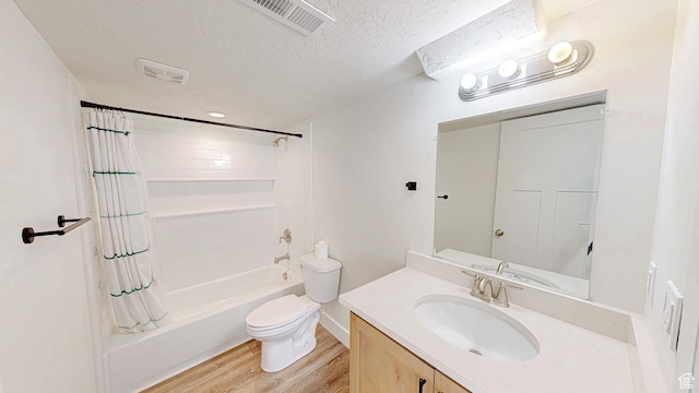 bathroom featuring wood finished floors, a textured ceiling, toilet, shower / bathtub combination with curtain, and vanity