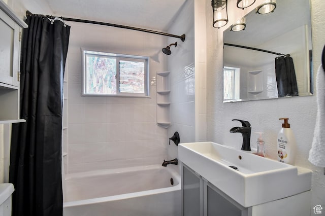 bathroom featuring shower / bath combo with shower curtain, toilet, vanity, and a textured wall