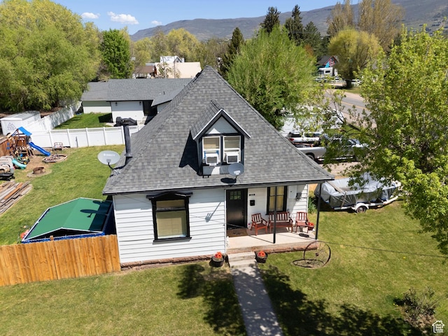 view of front of home with a shingled roof, a porch, and a mountain view