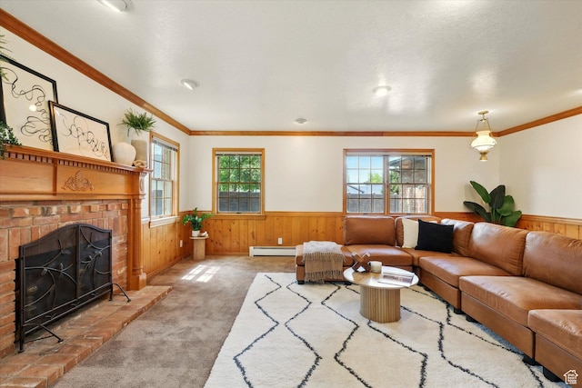 carpeted living area featuring a wainscoted wall, a baseboard heating unit, plenty of natural light, wooden walls, and a brick fireplace