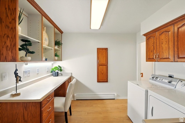 clothes washing area with cabinet space, baseboard heating, separate washer and dryer, light wood-type flooring, and an office area