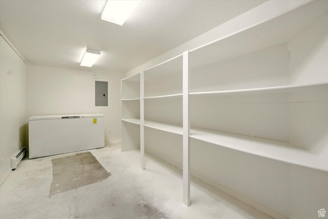 basement with electric panel, fridge, and a baseboard radiator