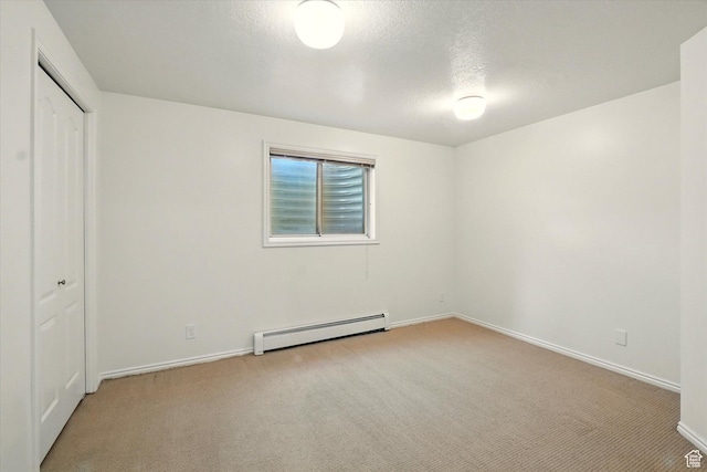 unfurnished bedroom with a baseboard heating unit, light colored carpet, baseboards, a closet, and a textured ceiling