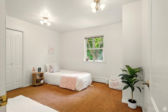 carpeted bedroom with a baseboard radiator, a closet, and baseboards
