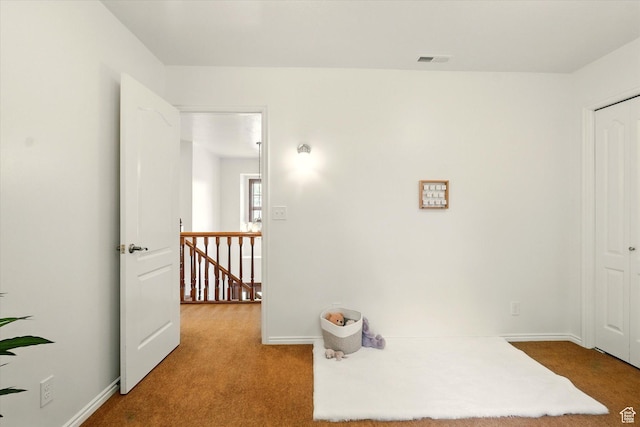 corridor with an upstairs landing, carpet, and baseboards