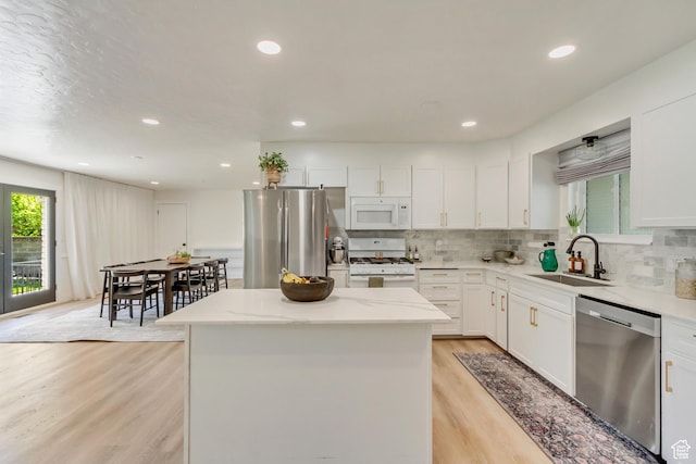 1145 S 350 W, Orem, UT 84058 - kitchen with stainless steel appliances, a sink, light wood-style flooring, a kitchen island, and backsplash