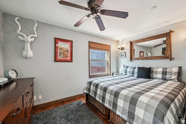 bedroom featuring wood finished floors, baseboards, and a ceiling fan