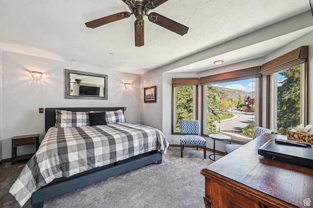 carpeted bedroom featuring baseboards and a ceiling fan