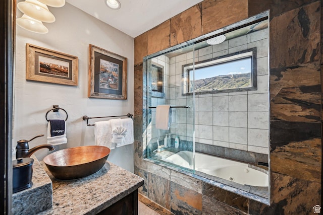 bathroom featuring a tile shower, a whirlpool tub, and vanity