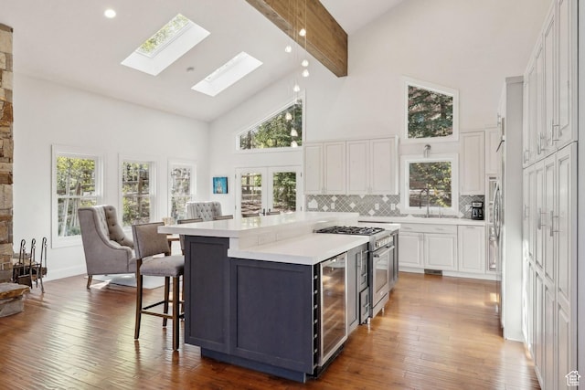 3339 W Big Spruce Way, Park City, UT 84098 - kitchen featuring high vaulted ceiling, beverage cooler, white cabinets, high end stainless steel range oven, and light countertops