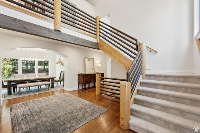 3339 W Big Spruce Way, Park City, UT 84098 - staircase featuring arched walkways, wood finished floors, a high ceiling, and baseboards