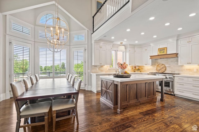 1971 Summerwood Dr, Farmington, UT 84025 - kitchen with stainless steel stove, light countertops, a chandelier, white cabinetry, and tasteful backsplash