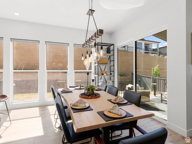 dining space with wood finished floors and recessed lighting