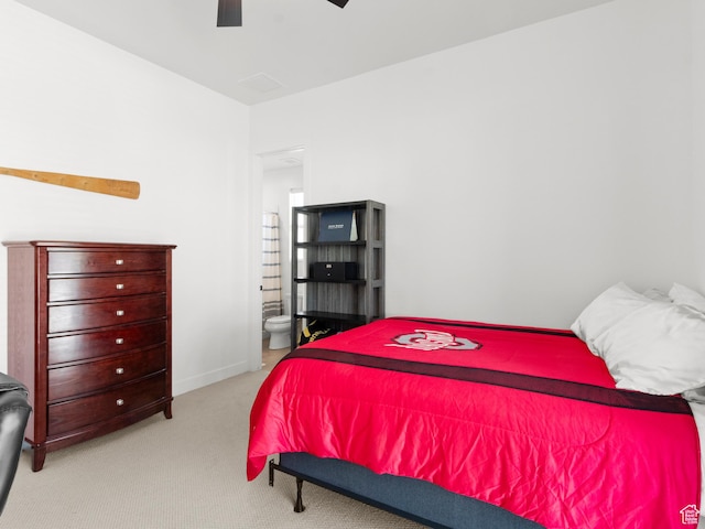 bedroom with carpet floors, ensuite bath, and a ceiling fan