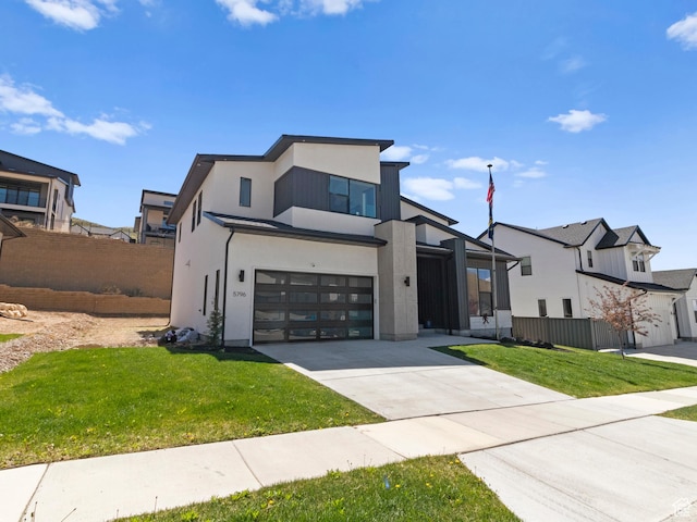 contemporary home with a garage, driveway, and stucco siding