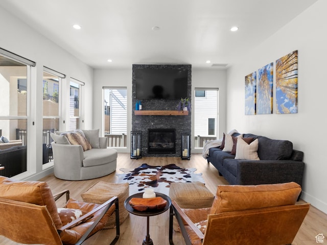 living area featuring a fireplace, healthy amount of natural light, recessed lighting, and light wood-style floors