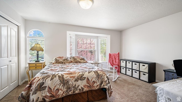 carpeted bedroom with a closet and a textured ceiling