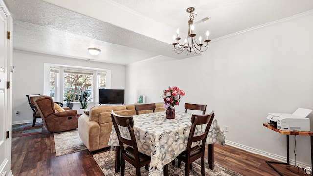 dining room with dark wood-type flooring, a chandelier, crown molding, baseboards, and a textured ceiling