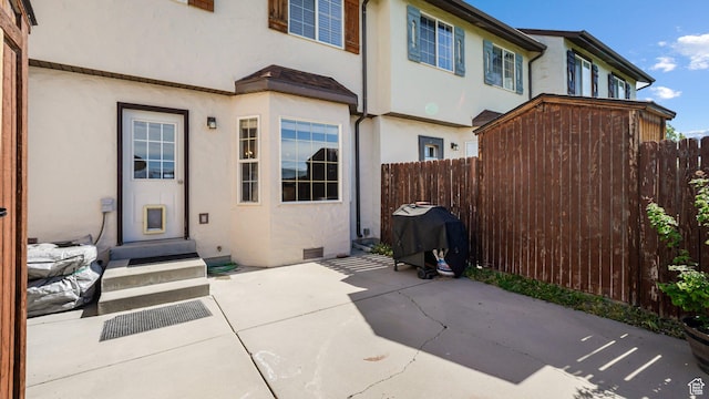 back of property featuring fence, stucco siding, and a patio