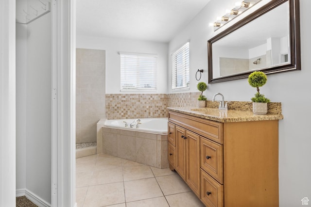 full bathroom featuring a garden tub, vanity, tile patterned floors, and a tile shower