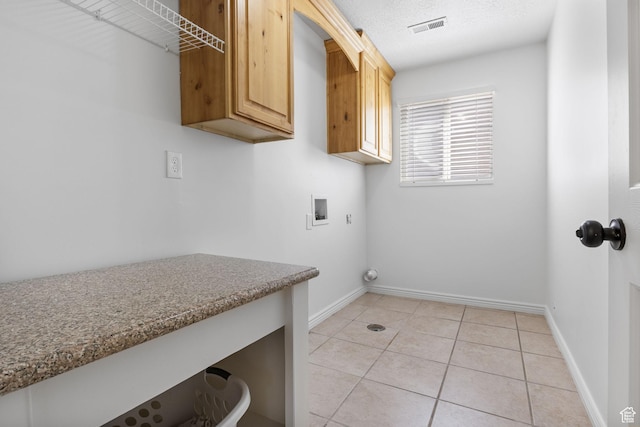 washroom with hookup for a washing machine, cabinet space, baseboards, and light tile patterned flooring